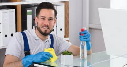 a young man cleaning glass with cloth and cleaner