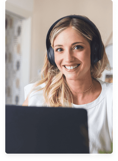 a smiling woman working on a laptop