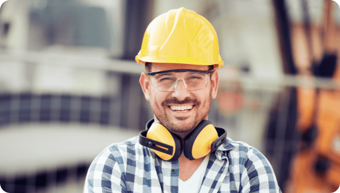 A contractor with Yellow helmet smiling for a portrait