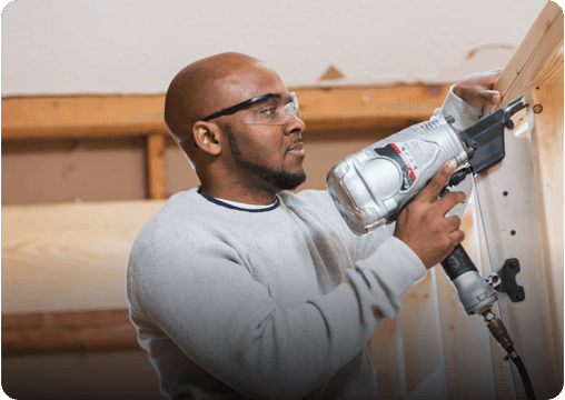 a man holding a drilling machine
